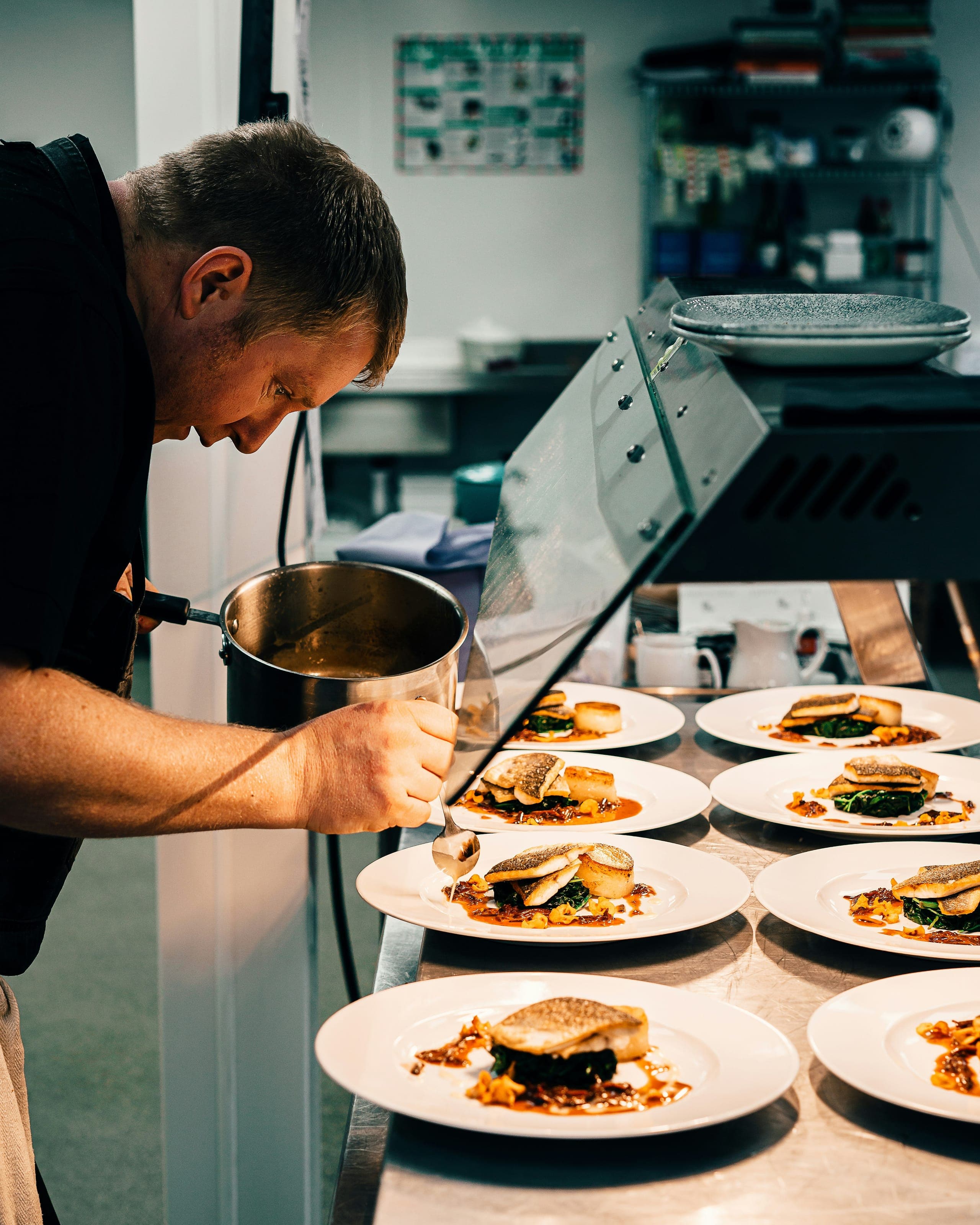 The chef plating a dish with precise, deliberate hands
