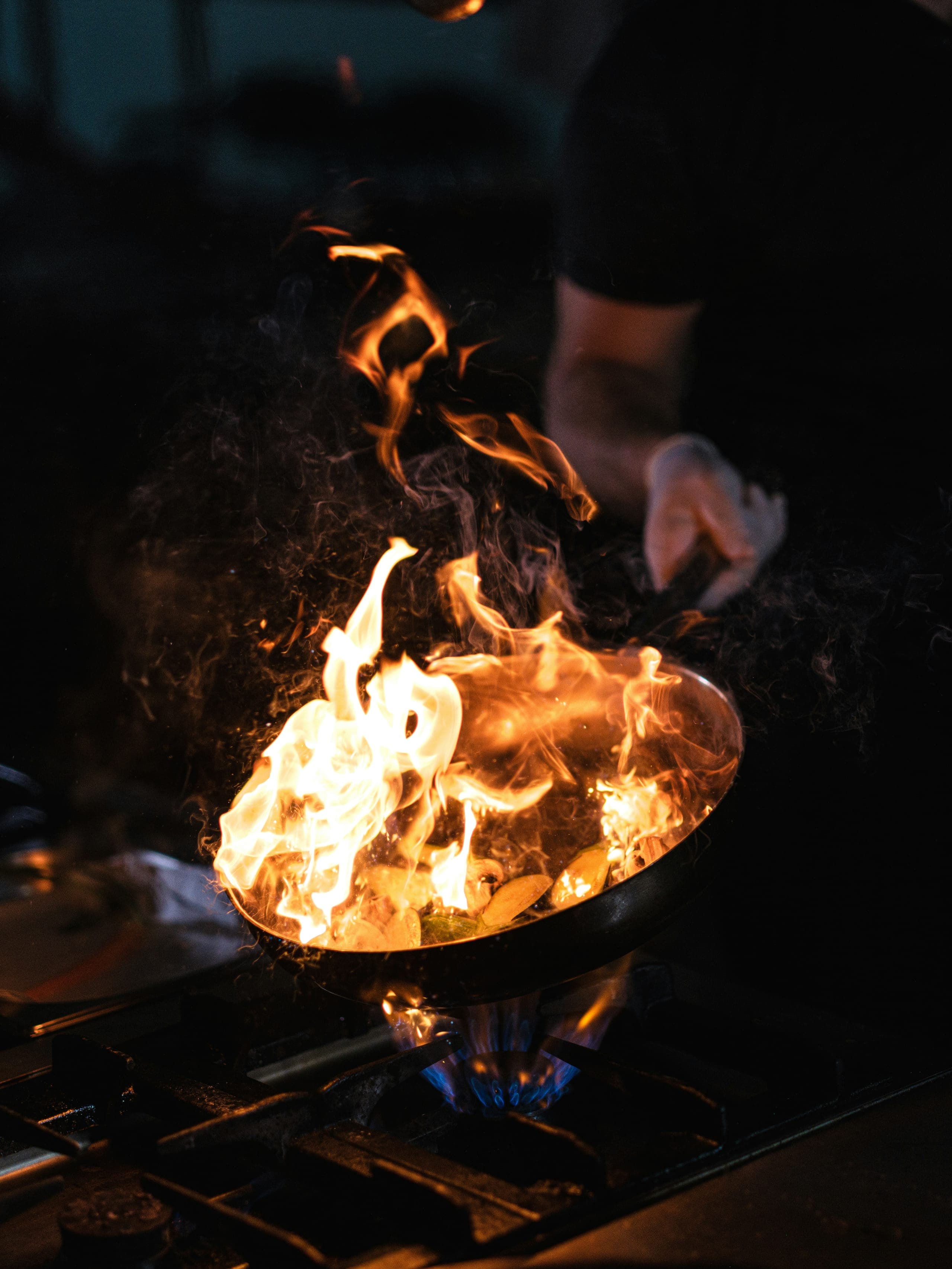 Flames leaping from a wok in the Sanbay Fusion kitchen